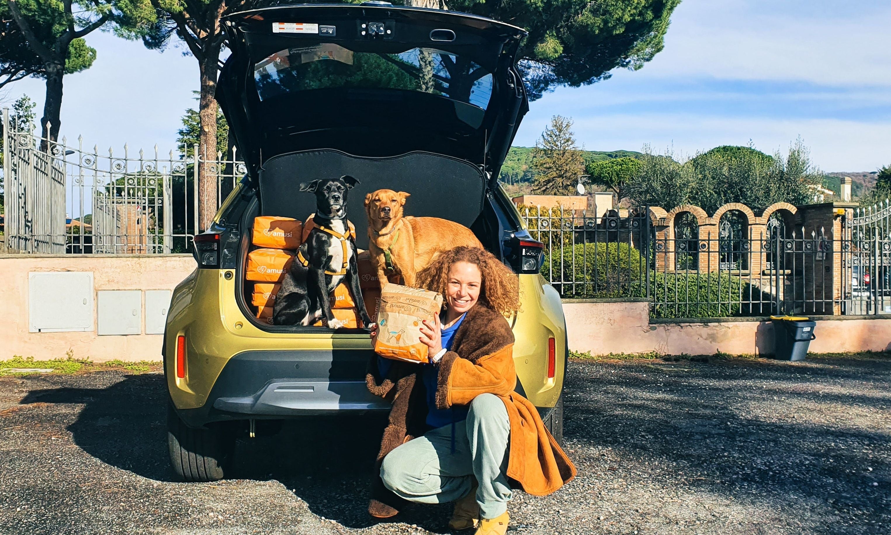 francesca con i suoi cani e la macchina piena di crocchette amusi